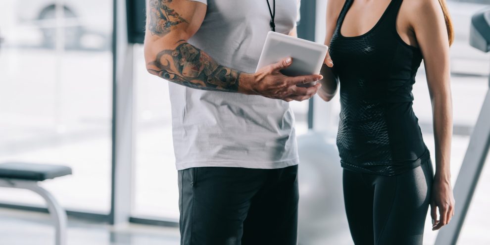 cropped image of male personal trainer showing schedule on digit